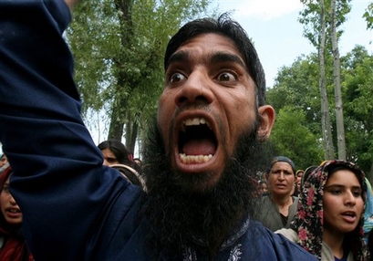 A Kashmiri protester shouts pro-freedom and pro-Pakistan slogans during the joint funeral procession of Bilal Ahmed Dar and two rebels in the village of Narwara, some 40 Kilometers (25 miles) southwest of Srinagar, India, Tuesday, June 19, 2007. Thousands of people marched in Indian-controlled Kashmir Tuesday protesting the killing of 17-year-old Bilal Ahmed Dar by government forces, who locals claim had no ties to militant groups. The teen was killed along with two rebels Monday in a gun battle between police and suspected Kashmiri rebels in the village of Chewdara. (AP Photo/Rafiq Maqbool)